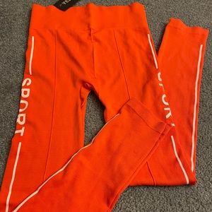 Red stretchy leggings with white sports words.